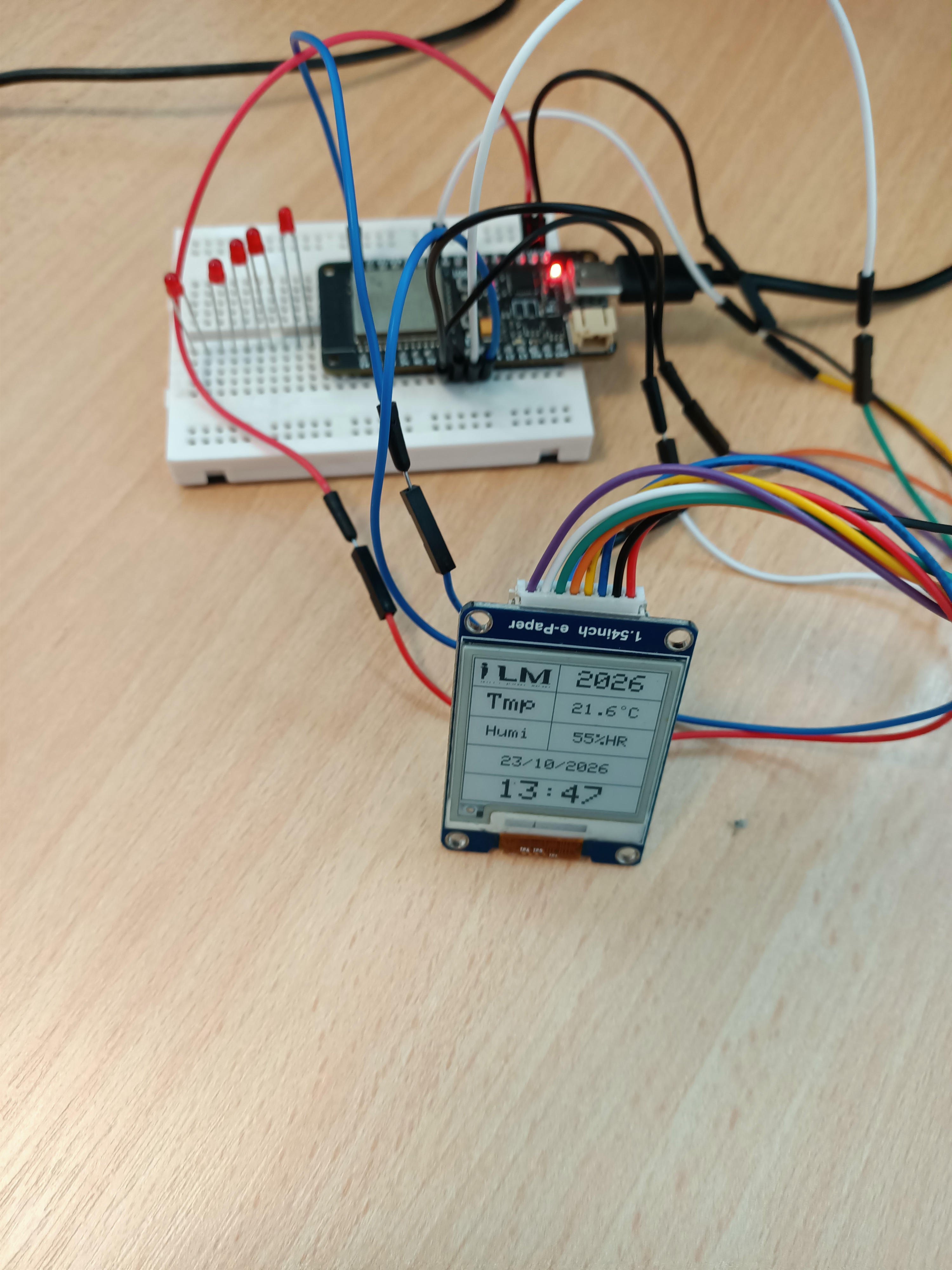 ESP32 connected to an e-paper screen showing simulated temperature and humidity